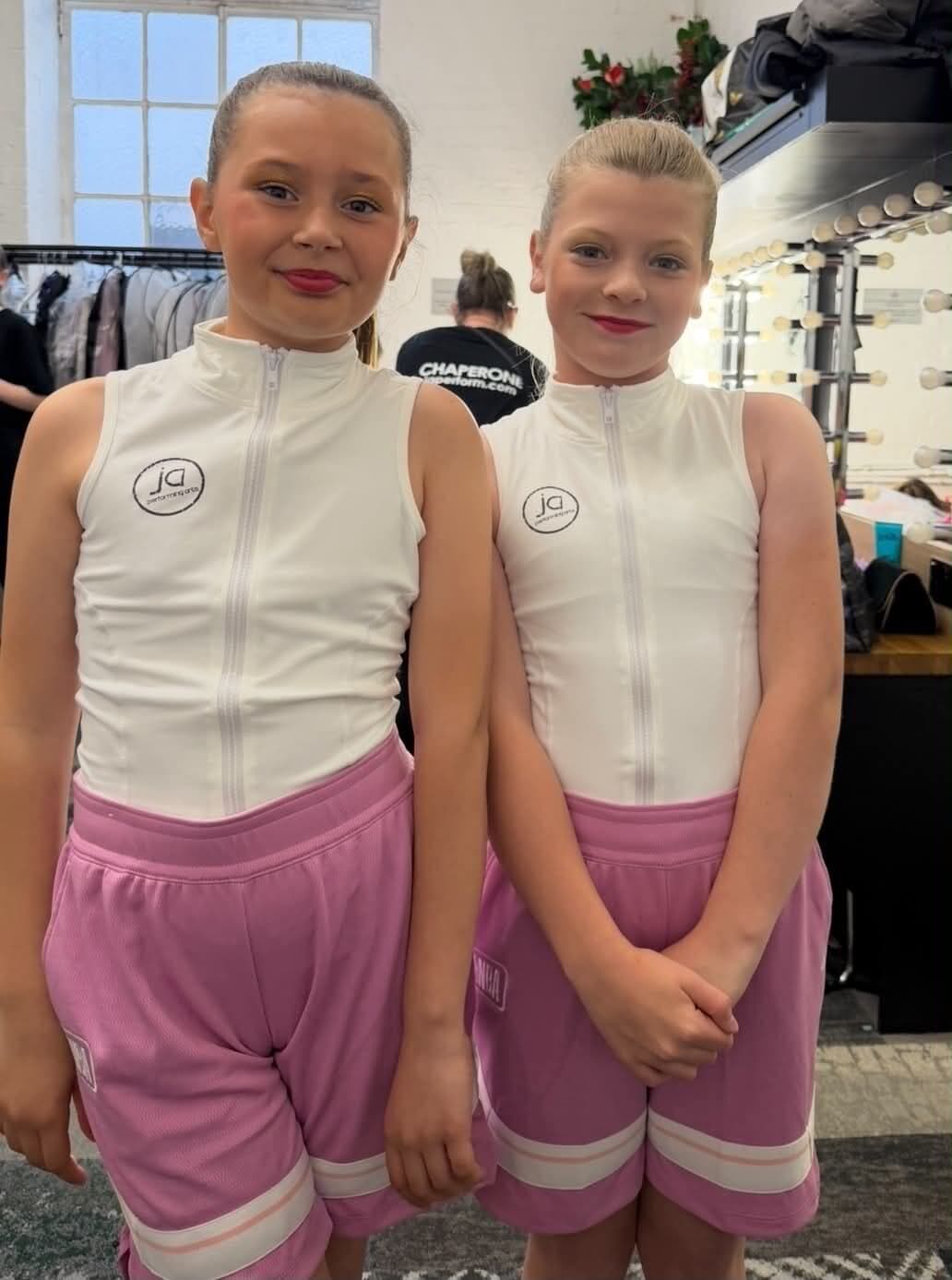 Two dancers in JA branded kit backstage